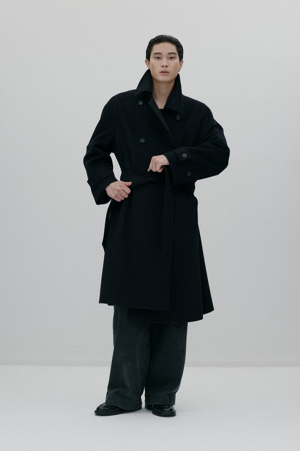 네이비 컬러의 오버사이즈드 웨이스트 벨트 코트입니다. 울과 캐시미어 혼방 소재로 제작되어 부드러운 촉감과 두꺼운 두께로 뛰어난 보온성을 자랑합니다. 클래식하고 모던한 디자인으로, 롱 기장의 더블 코트이며, 허리 부분의 웨이스트 벨트가 특징입니다. 뒷중심 벤트, 소매 밴드 버튼, 암홀 패브릭 밴드와 같은 디테일이 돋보이며, 안감은 폴리에스터와 레이온으로 마감되었습니다. 출근룩, 오피스룩, 겨울 데일리룩 등 다양한 TPO에 활용 가능하며, 미니멀하고 시크한 스타일을 연출하기 좋습니다.

