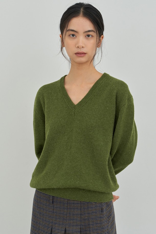올리브그린 컬러의 클래식 V넥 니트입니다. 여성용으로, 가을과 겨울에 따뜻하게 착용할 수 있으며, 레귤러핏으로 제작되었습니다. 부드러운 울 소재에 긴 소매 기장으로 포근함을 더하였으며, 무지 디자인으로 미니멀하고 클래식한 스타일을 연출합니다. 출근룩에 잘 어울리는 두꺼운 두께감의 니트입니다.
