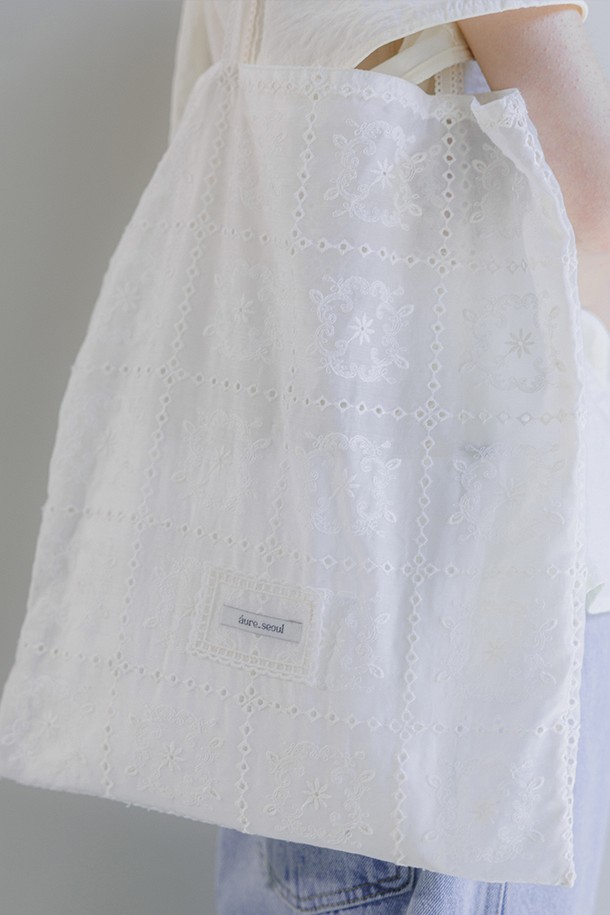 아이보리 컬러의 레이스 에코백입니다. 면, 레이온, 나일론 혼방 소재로 부드러운 촉감을 선사하며, 사각 모양에 심플한 디자인이 돋보입니다. 레이스 패턴과 레이스 라벨 디테일이 우아한 분위기를 더하며, 데일리룩에 포인트를 줄 수 있습니다. 넉넉한 수납이 가능한 실용적인 가방으로, 베이직, 미니멀, 로맨틱 스타일을 즐겨 입는 여성분들께 추천합니다. 자연스러운 실루엣과 따뜻한 색감으로 완성도를 높였습니다.
