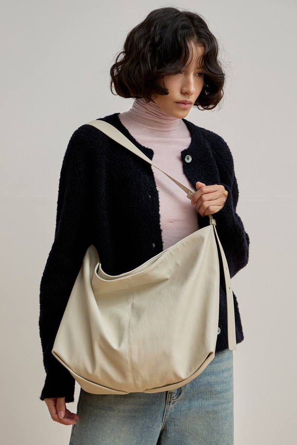 루네 멀티백 [크림]은 미니멀하고 모던한 스타일을 추구하는 여성들을 위한 라지 사이즈의 멀티백입니다. 비건 가죽 소재로 제작되었으며, 크림 컬러의 무지 디자인이 특징입니다. 오버사이즈 사각 쉐입에 숄더 및 크로스바디로 연출 가능하며, 비대칭 스트랩과 오리가미 스타일 바닥으로 세련된 포인트를 더했습니다. 내부에는 노트북 수납 공간과 다양한 수납을 위한 지퍼 포켓 및 오픈 포켓이 있어 실용적입니다. 오피스룩에 완벽하게 어울리는 데일리 가방으로, 마그네틱 잠금 방식으로 간편하게 사용할 수 있습니다.
