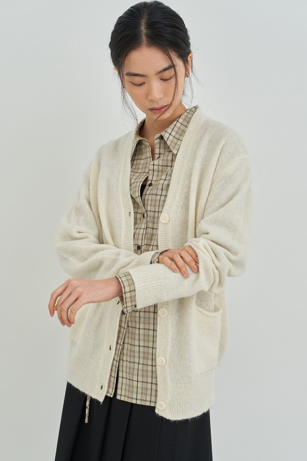 아이보리 컬러의 오버핏 니트 가디건입니다. 부드러운 촉감의 두꺼운 니트 소재로 제작되어 가을, 겨울철 따뜻하게 착용하기 좋습니다. 브이넥 라인과 버튼 디테일이 돋보이며, 캐주얼 및 미니멀 스타일 연출에 용이합니다. 데이트룩, 모임룩 등 다양한 TPO에 활용 가능하며, 넉넉한 오버핏으로 편안한 착용감을 선사합니다. 무지 디자인으로 베이직하면서도 세련된 느낌을 줍니다.
