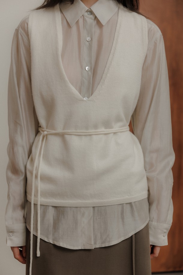 **레이어 니트 베스트 [2colors]**

부드러운 울 소재로 제작되어 포근한 착용감을 선사하는 여성 레이어 니트 베스트입니다. 아이보리와 블랙, 두 가지 색상으로 출시되어 데일리룩부터 오피스룩까지 다양한 스타일을 연출할 수 있습니다. 넉넉한 릴랙스핏과 브이넥 디자인, 허리 스트랩 디테일이 특징이며, 뒷면 텍스처로 포인트를 더했습니다. 가을, 겨울 시즌에 두꺼운 두께감으로 따뜻하게 착용 가능하며 미니멀하고 클래식한 무드를 완성합니다. 넉넉한 암홀 디자인과 프리미엄 마감 처리로 편안함과 고급스러움을 동시에 느낄 수 있습니다.
