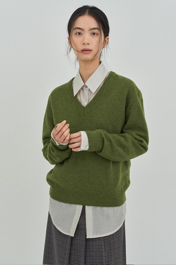올리브그린 컬러의 클래식 V넥 니트입니다. 여성용으로, 가을과 겨울에 따뜻하게 착용할 수 있으며, 레귤러핏으로 제작되었습니다. 부드러운 울 소재에 긴 소매 기장으로 포근함을 더하였으며, 무지 디자인으로 미니멀하고 클래식한 스타일을 연출합니다. 출근룩에 잘 어울리는 두꺼운 두께감의 니트입니다.
