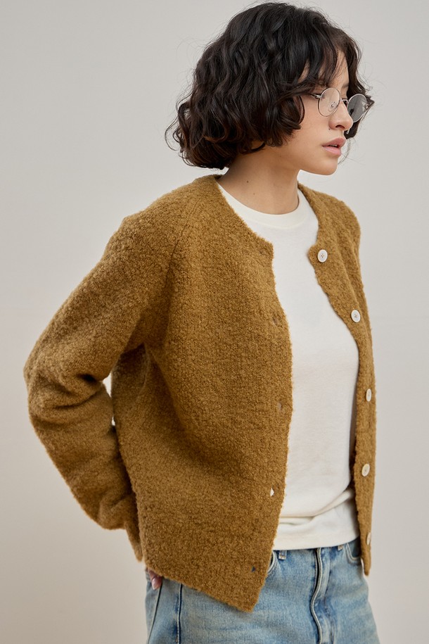 따뜻하고 포근한 젠틀 부클 가디건 [카멜]입니다. 울, 나일론, 스판덱스 혼방 소재로 제작되어 부드러운 촉감과 뛰어난 보온성을 자랑하며, 롱 기장과 릴랙스 핏으로 편안한 착용감을 선사합니다. 부클 패턴과 싱글 버튼, 래글런 소매 디테일, 그리고 은은하게 빛나는 진주 단추가 클래식하고 여성스러운 분위기를 더합니다. 출근룩, 모임룩 등 다양한 TPO에 활용 가능하며, 미니멀하고 클래식한 스타일을 즐기는 여성분들께 추천합니다. 겨울철 따뜻함과 스타일을 동시에 잡으세요.
