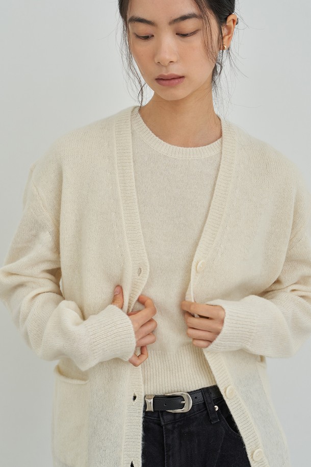 아이보리 컬러의 오버핏 니트 가디건입니다. 부드러운 촉감의 두꺼운 니트 소재로 제작되어 가을, 겨울철 따뜻하게 착용하기 좋습니다. 브이넥 라인과 버튼 디테일이 돋보이며, 캐주얼 및 미니멀 스타일 연출에 용이합니다. 데이트룩, 모임룩 등 다양한 TPO에 활용 가능하며, 넉넉한 오버핏으로 편안한 착용감을 선사합니다. 무지 디자인으로 베이직하면서도 세련된 느낌을 줍니다.
