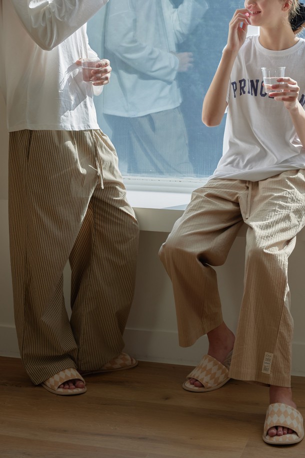 [오디넌트] 브린 순면 파자마 팬츠는 편안한 수면을 위한 공용 파자마 팬츠입니다. 부드러운 순면 소재로 제작되어 사계절 내내 쾌적하게 착용 가능하며, 집콕룩으로 안성맞춤입니다. 브라운 컬러에 세로 스트라이프 패턴이 적용되어 캐주얼하면서도 미니멀한 스타일을 연출합니다. 허리 밴딩 처리와 반바지 길이로 편안한 착용감을 선사하는 실용적인 아이템입니다.
