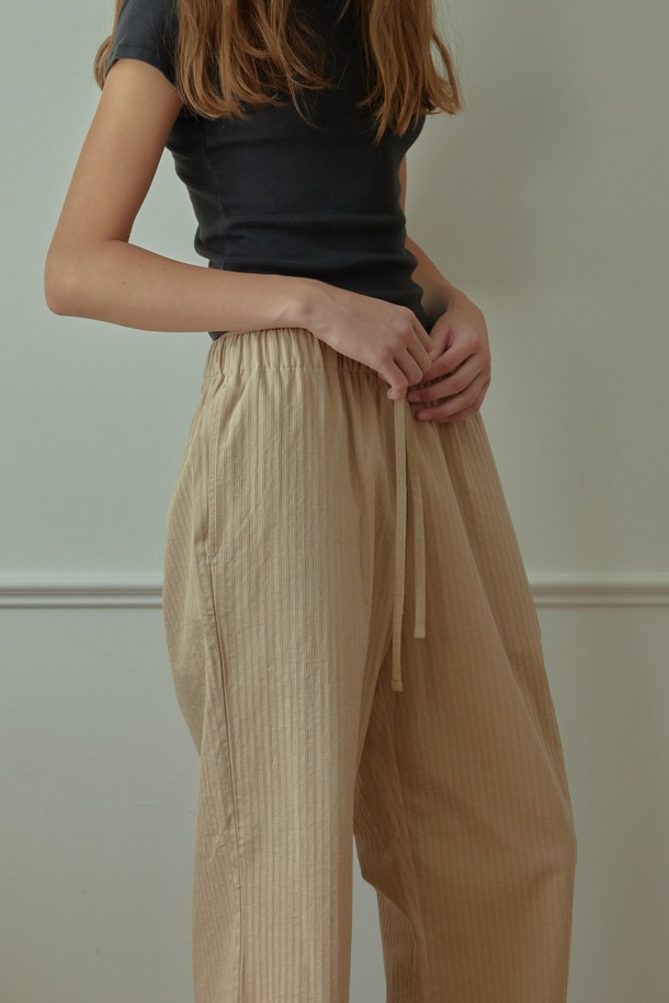 [오디넌트] 브린 순면 파자마 팬츠는 편안한 수면을 위한 필수템입니다. 베이지 색상의 무지 디자인으로, 미니멀하고 캐주얼한 집콕룩, 휴가룩을 연출하기 좋습니다. 부드러운 순면 소재로 제작되어 사계절 내내 통기성이 뛰어나 쾌적한 착용감을 제공합니다. 허리 밴딩과 스트링으로 체형에 맞게 조절 가능하며, 편안한 활동성을 보장합니다. 단품으로 구성되어 있으며, 어떤 상의와도 쉽게 매치하여 편안한 수면 시간을 즐길 수 있습니다.
