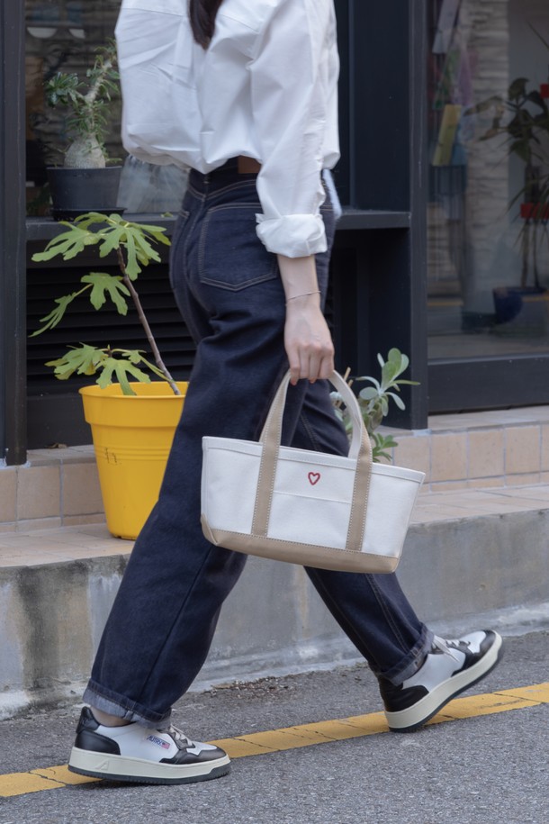 [오디넌트] 코렛 하트 토트백은 아이보리와 베이지 컬러의 캔버스 소재로 제작된 여성용 토트백입니다. 미디엄 사이즈의 사각 가방 형태로, 하트 자수 디테일이 돋보이며 투톤 배색으로 디자인되었습니다. 오픈형 잠금 방식을 채택하여 편리하게 사용 가능하며, 캐주얼한 디자인으로 데일리 가방으로 활용하기 좋습니다. 사랑스러운 하트 무늬가 특징인 이 토트백은 편안하면서도 스타일리시한 매력을 선사합니다.
