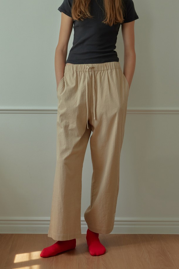 [오디넌트] 브린 순면 파자마 팬츠는 편안한 수면을 위한 필수템입니다. 베이지 색상의 무지 디자인으로, 미니멀하고 캐주얼한 집콕룩, 휴가룩을 연출하기 좋습니다. 부드러운 순면 소재로 제작되어 사계절 내내 통기성이 뛰어나 쾌적한 착용감을 제공합니다. 허리 밴딩과 스트링으로 체형에 맞게 조절 가능하며, 편안한 활동성을 보장합니다. 단품으로 구성되어 있으며, 어떤 상의와도 쉽게 매치하여 편안한 수면 시간을 즐길 수 있습니다.
