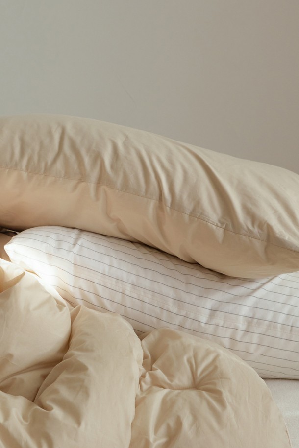 [오디넌트] 모플리 양면 베개커버는 부드러운 면 소재로 제작되어 편안한 촉감을 선사합니다. 양면 사용이 가능하여 실용적이며, 침구류와 함께 활용하기 좋습니다. 은은한 베이지 색상의 무지 디자인으로 어떤 침실에도 잘 어울립니다.
