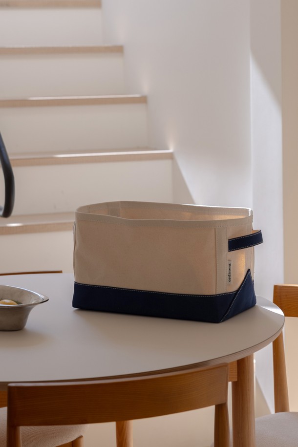 [오디넌트] 데이 캔버스 스토리지_네이비는 캔버스 소재로 제작된 수납/정리용품입니다. 네이비와 베이지 컬러의 이중 배색 디자인이 특징이며, 넉넉한 수납 공간을 제공합니다. 무지 디자인으로 어떤 공간에도 잘 어울리며, 다양한 물품을 깔끔하게 정리할 수 있습니다. 일상생활에서 유용하게 사용되는 실용적인 수납 솔루션입니다. 캔버스 소재 특유의 질감으로 부드러운 느낌을 선사합니다.
