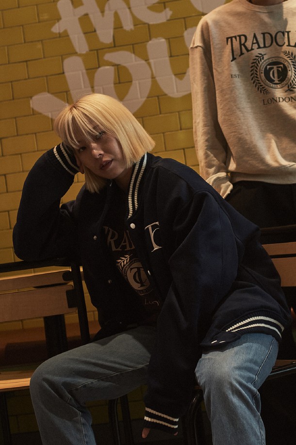 캠브리지 어센틱 바시티 재킷은 캐주얼, 스포티, 클래식 스타일을 아우르는 공용 아우터입니다. 톤 다운된 네이비 컬러에 로고 패턴이 돋보이며, 봄, 가을 시즌에 적합합니다. 두꺼운 울 소재로 제작되어 보온성을 높였으며, 긴 소매와 레귤러 기장으로 편안한 착용감을 선사합니다. 리브 디테일과 화이트 스트라이프 배색이 스포티한 무드를 더하며, 스냅 버튼 여밈 방식으로 간편하게 착용할 수 있습니다. 출근룩과 모임룩 등 다양한 TPO에 활용 가능합니다.
