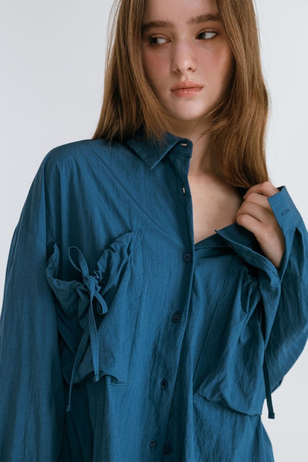 블루 컬러의 셔링 포켓 셔츠입니다. 캐주얼하고 미니멀한 스타일로, 봄과 여름에 시원하게 착용하기 좋습니다. 브이넥 디자인에 루즈핏으로 편안함을 더했으며, 크롭 기장과 얇은 두께감으로 가볍게 연출할 수 있습니다. 셔링 디테일과 포켓으로 포인트를 주어 밋밋함을 덜었습니다. 긴 소매에 오픈 프론트 스타일로 다양한 룩을 연출할 수 있습니다.
