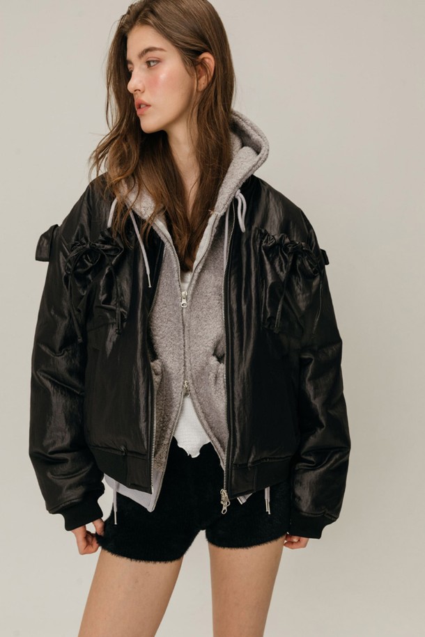 리본 봄버 재킷 / 블랙은 페미닌하면서도 캐주얼한 스타일을 연출하는 여성용 점퍼입니다. 부드러운 나일론 소재와 두꺼운 두께감으로 겨울철에도 따뜻하게 착용할 수 있습니다. 크롭 기장에 릴렉스핏과 루즈핏으로 편안함을 더했으며, 집업 스타일로 간편하게 입고 벗을 수 있습니다. 자연스러운 광택감과 리본 디테일이 돋보이며, 후드티와 레이어드하여 다양한 스타일을 연출할 수 있습니다. 데이트룩과 모임룩, 캐주얼 및 미니멀 스타일 모두 소화 가능한 활용도 높은 아이템입니다.
