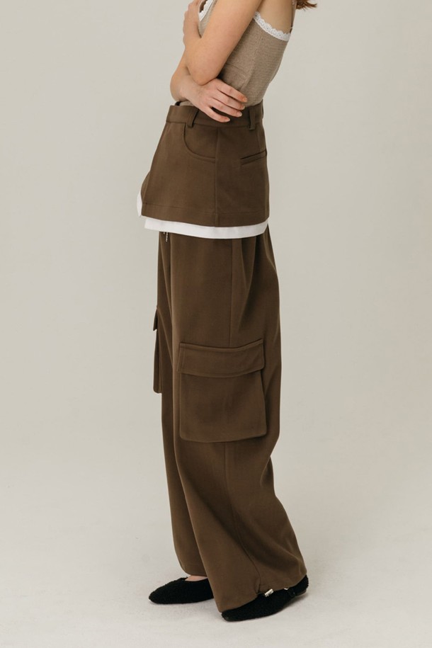 **CARGO 레이어드 스커트 팬츠 / 브라운**

캐주얼, 스트릿 무드의 카고 레이어드 스커트 팬츠입니다. 브라운 컬러의 와이드 핏 긴바지로, 가을, 겨울 시즌에 착용하기 좋습니다. 레이어드 디자인과 카고 포켓 디테일, 스커트 레이어 디자인이 특징입니다. 루즈핏으로 편안한 착용감을 선사합니다. 무지 패턴으로 다양한 상의와 매치하여 스타일리시하게 연출할 수 있습니다.
