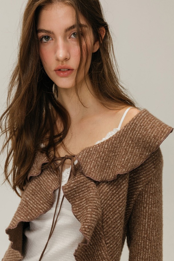 프릴 스트랩 가디건 / 브라운은 우아하고 페미닌한 스타일을 연출하는 여성용 니트/스웨터입니다. 톤 다운된 브라운 컬러에 프릴 넥과 스트랩 디자인이 더해져 로맨틱한 분위기를 자아냅니다. 두꺼운 두께감의 니트 소재로 제작되어 가을, 겨울 시즌에 따뜻하게 착용할 수 있으며, 일상, 데이트룩, 모임룩, 출근룩 등 다양한 TPO에 활용 가능합니다. 레귤러핏 크롭 기장으로 다리가 길어 보이는 효과를 주며, 부드러운 촉감이 특징입니다. 클래식, 미니멀, 로맨틱 스타일을 즐겨 입는 분들께 추천합니다.
