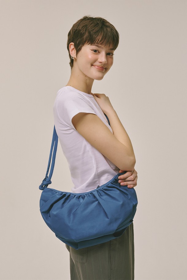 Halfmoon hobo bag Blue (하프문 호보 백 블루)는 여성용 미디엄 사이즈 호보백입니다. 블루, 브라운, 블랙 세 가지 색상으로 출시되었으며, 나일론과 폴리에스테르 소재로 제작되어 튼튼합니다. 스트랩 길이 조절이 가능하며, 더스트백이 포함되어 있어 보관이 용이합니다. 반원 모양에 무지 디자인으로, 미니멀, 캐주얼, 클래식 스타일의 데이트룩 및 쇼핑룩에 잘 어울립니다.
