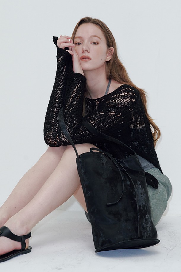 블랙 색상의 버킷 백입니다. 폴리우레탄과 폴리에스테르 소재로 제작되었으며, 미디엄 사이즈로 데이트룩, 쇼핑룩, 카페룩 등 다양한 TPO에 잘 어울립니다. 미니멀, 클래식, 캐주얼 스타일을 즐겨 입는 여성분들께 추천하며, 무지 디자인에 스트랩 탈부착이 가능하여 실용성을 더했습니다. 가방 안에는 조임용 끈이 있어 소지품을 안전하게 보관할 수 있으며, 더스트백과 금속 부자재가 포함되어 있습니다.
