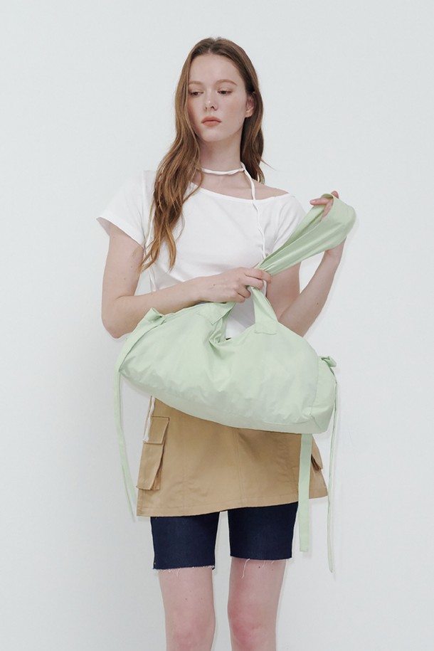 "피그테일 리본 백 그린"은 여성스러운 데이트룩과 카페룩에 잘 어울리는 리본 디테일의 미디엄 사이즈 가방입니다. 나일론과 폴리에스테르 소재로 제작되어 가볍고, 라벤더 그린, 블루 블랙, 그레이 세 가지 컬러로 출시되었습니다. 걸리시, 미니멀, 클래식 스타일을 모두 소화할 수 있으며, 자연스러운 주름이나 자국이 있을 수 있습니다. 더스트백이 포함되어 보관이 용이하며, 모니터 설정에 따라 색상 차이가 있을 수 있습니다. 보관 시에는 더스트백 사용을 권장합니다.
