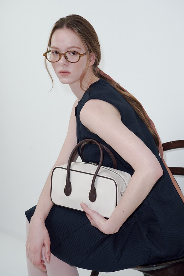 아이보리 & 브라운 컬러의 바게트 벤토 백입니다. 폴리우레탄과 폴리에스테르 소재로 제작되었으며, 미디엄 사이즈의 무지 디자인으로 제작되었습니다. 숄더 스트랩 조절이 가능하여, 쇼핑룩이나 카페룩 등 다양한 TPO에 활용하기 좋습니다. 더스트백이 포함되어 있어 보관이 용이하며, 미니멀, 클래식, 캐주얼 스타일을 즐기는 여성분들에게 추천합니다. 수분 및 직사광선에 노출되지 않도록 주의하여 관리하고, 품질 보증 기간은 6개월입니다.
