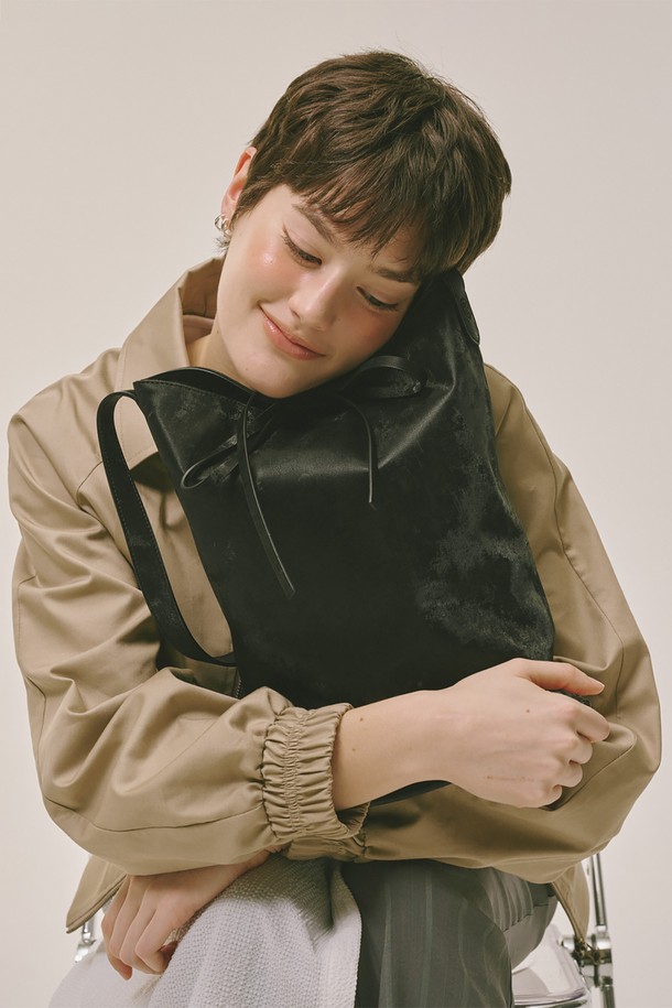 블랙 색상의 버킷 백입니다. 폴리우레탄과 폴리에스테르 소재로 제작되었으며, 미디엄 사이즈로 데이트룩, 쇼핑룩, 카페룩 등 다양한 TPO에 잘 어울립니다. 미니멀, 클래식, 캐주얼 스타일을 즐겨 입는 여성분들께 추천하며, 무지 디자인에 스트랩 탈부착이 가능하여 실용성을 더했습니다. 가방 안에는 조임용 끈이 있어 소지품을 안전하게 보관할 수 있으며, 더스트백과 금속 부자재가 포함되어 있습니다.
