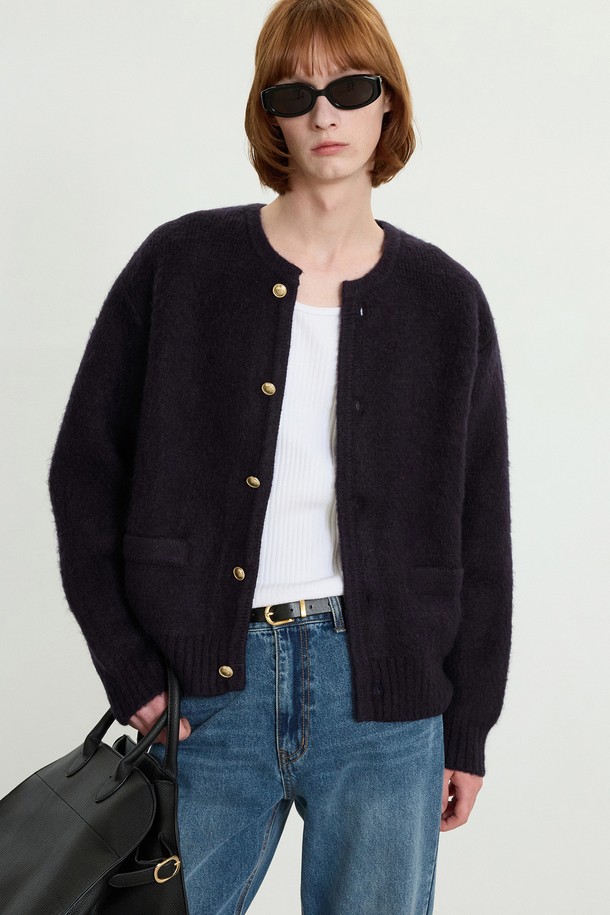 골드 버튼 모헤어 가디건 (네이비) TNSW5F103N2는 여성스러운 무드를 연출하는 클래식 & 베이직 스타일의 니트 가디건입니다. 부드러운 촉감의 모헤어 소재로 제작되었으며, 두께감이 있어 가을과 겨울에 따뜻하게 착용할 수 있습니다. 톤온톤의 네이비 컬러에 골드 버튼 장식이 더해져 고급스러운 포인트를 더했습니다. 라운드넥과 루즈핏 디자인으로 편안한 착용감을 선사하며, 데이트룩, 모임룩, 출근룩 등 다양한 TPO에 활용 가능합니다. 미니멀하면서도 시크한 매력을 뽐낼 수 있는 아이템입니다.

