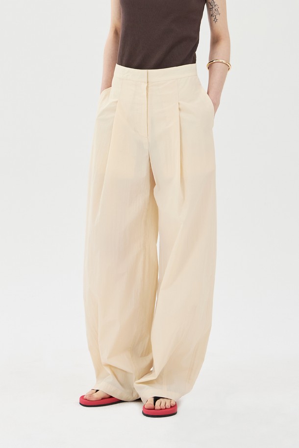 베이직한 무드의 턱 디테일 와이드핏 팬츠입니다. 면과 나일론 혼방 소재로 제작되어 여름에도 시원하게 착용 가능하며, 쿨한 촉감과 얇은 두께감으로 편안함을 선사합니다. 넉넉한 와이드 핏과 턱, 다트 디테일, 사이드 및 장식 포켓, 버튼과 후크 클로징으로 디자인적인 완성도를 높인 남녀 공용 캐주얼 팬츠입니다.
