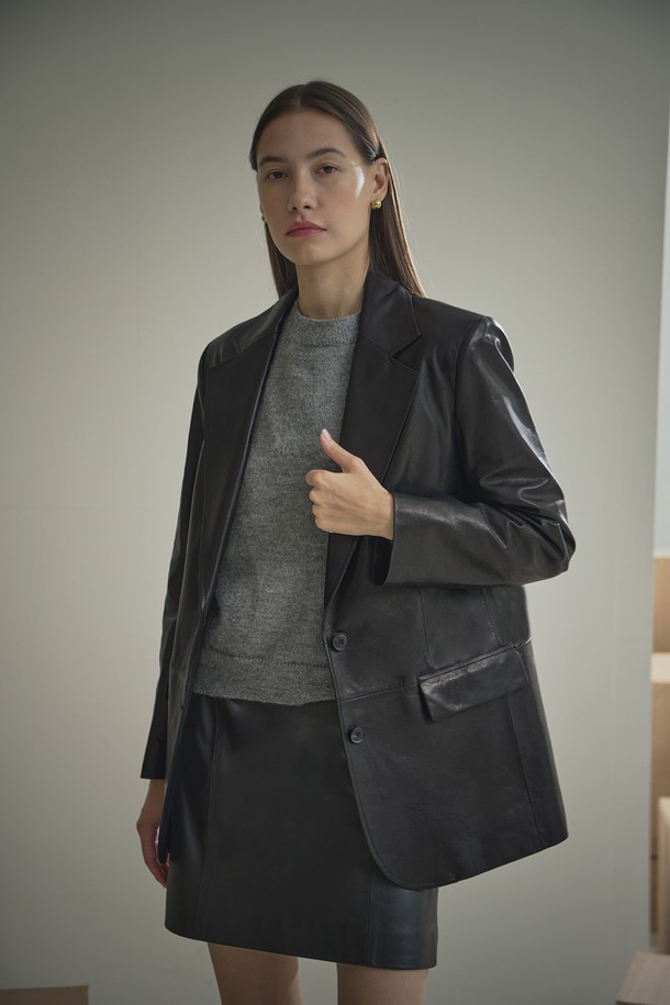 세련된 스타일을 완성하는 여성용 '베지터블 테일러드 싱글 재킷'입니다. 부드러운 램스킨 소재로 제작되어 고급스러운 촉감과 은은한 광택을 자랑합니다. 블랙 컬러에 레귤러핏, 싱글 버튼 여밈으로 깔끔하고 클래식한 분위기를 연출하며, 오피스룩, 모임룩, 소개팅룩 등 다양한 TPO에 활용하기 좋습니다. 6MM 어깨 패드와 전체 안감 처리, 소뿔 단추, 리얼 레더 라벨 디테일이 돋보이며, 가을 시즌에 시크하고 미니멀한 스타일을 완성해 보세요.
