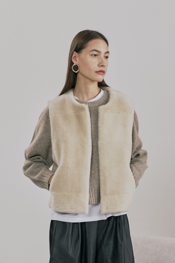 업사이클링 메리노 스트레이트 무스탕 베스트는 가을, 겨울 시즌 당신의 스타일을 완성해 줄 여성 베스트입니다. 베이지 컬러에 미니멀한 무드를 더했으며, 출근룩과 모임룩 모두 소화 가능한 활용도가 높은 아이템입니다. 부드러운 촉감의 메리노 소재와 무스탕의 조화가 고급스러운 분위기를 자아내며, 스트레이트 핏과 크롭 기장으로 세련된 실루엣을 연출합니다. 특히, 업사이클링 소재를 사용하여 환경까지 생각한 가치 소비를 실현할 수 있으며, 사이드 포켓과 절개선 스티치 디테일이 돋보입니다.
