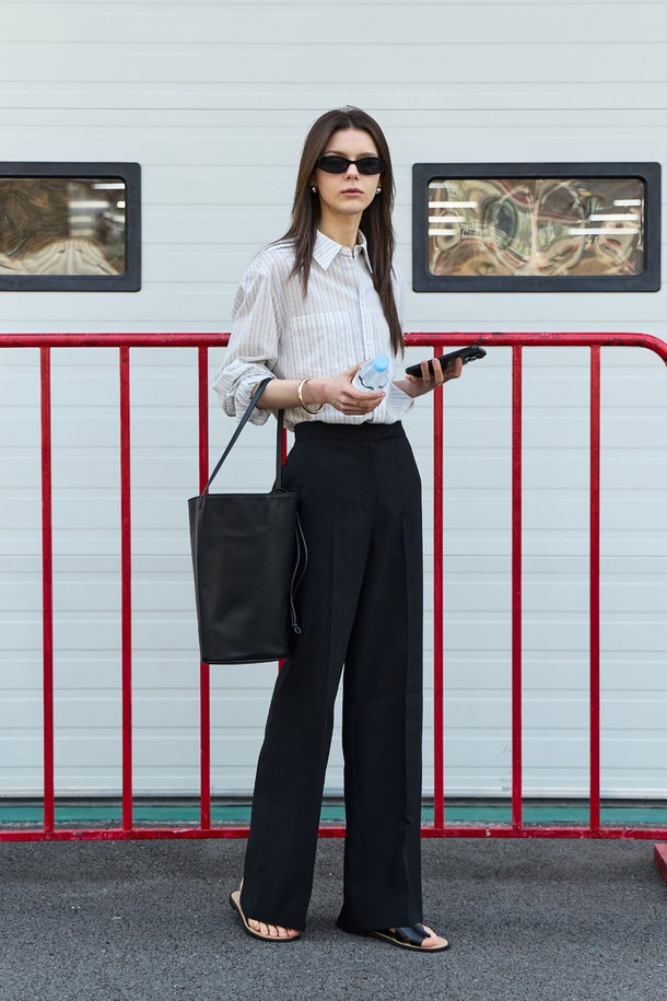 세련된 블랙 컬러의 슬릿 스트레이트 팬츠입니다. 얇은 폴리에스테르 소재로 제작되어 여름에도 시원하게 착용 가능하며, 미니멀하고 모던한 스타일을 연출합니다. 슬림핏으로 다리 라인을 슬림하게 잡아주며, 뒷면 트임 디테일과 트임 부분 배색으로 포인트를 더했습니다. 후크와 버튼 클로징, 사이드 포켓이 있으며, 안감은 없습니다.
