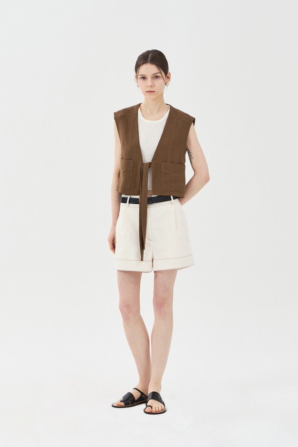브라운 색상의 린넨 브이넥 베스트는 여름철 일상에서 클래식하고 캐주얼한 스타일을 연출하기에 좋습니다. 린넨, 레이온, 면 혼방 소재로 제작되었으며, 브이넥 디자인과 아웃포켓, 스티치 디테일, 허리 스트랩이 특징입니다. 레귤러핏과 루즈핏의 중간 형태로 민소매 디자인이며, 크롭 기장으로 제작되었습니다.
