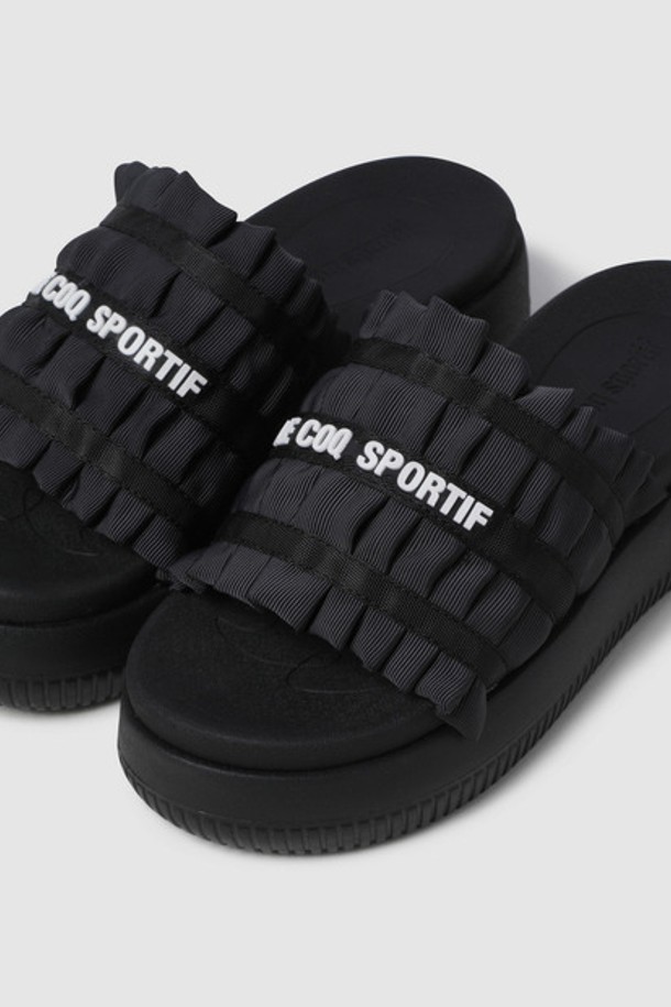 **러플 슬라이드 - 블랙(QQ322LSD72)**

여성스러운 매력을 더하는 러플 장식의 블랙 슬라이드입니다. 폴리에스터와 나일론 혼방 소재로 제작되어 편안한 착용감을 선사하며, 4.5cm 굽 높이의 플랫 플랫폼 디자인으로 키높이 효과를 줍니다. 안감은 폴리에스터 소재이며, 발을 부드럽게 감싸줍니다. 캐주얼, 걸리시, 미니멀 스타일의 동네 마실룩, 휴가룩, 여행룩에 잘 어울리는 아이템입니다. 파일론 밑창으로 편안함과 스타일을 동시에 잡았습니다.
