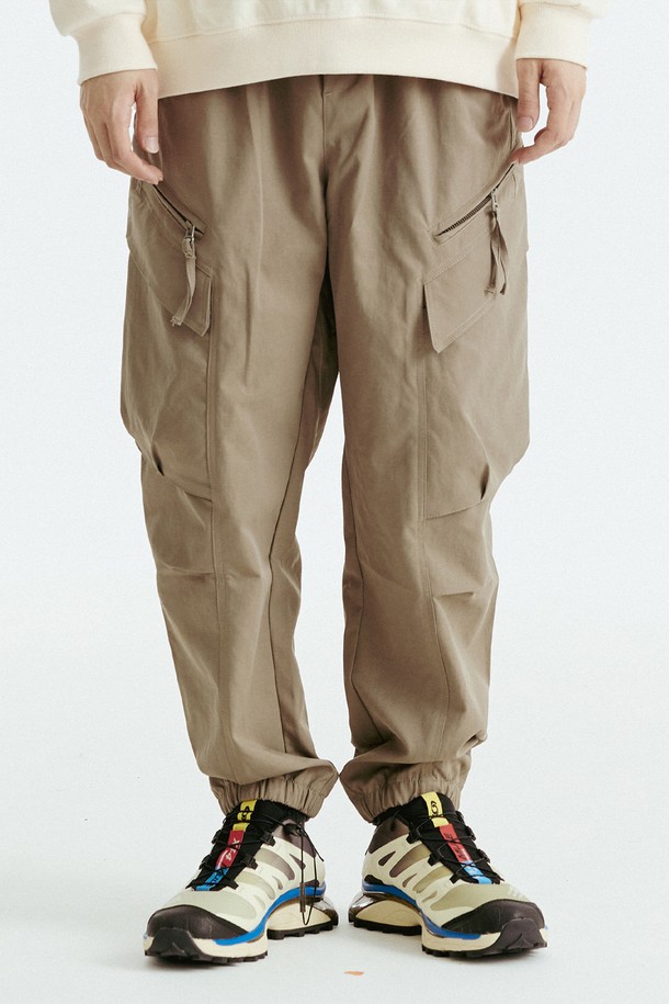 블랙과 카키 컬러로 출시된 지퍼 카고 조거 팬츠입니다. 봄, 가을 시즌에 적합하며, 폴리에스테르 소재로 제작되어 편안한 착용감을 제공합니다. 릴랙스 핏에 조거 스타일로 활동성을 높였으며, 허리 밴딩으로 편안함을 더했습니다. 캐주얼, 스트리트, 미니멀 스타일을 모두 소화할 수 있으며, 일상 및 여행 시에도 활용하기 좋습니다. 카고 포켓과 지퍼 디테일로 포인트를 더한 디자인입니다.
