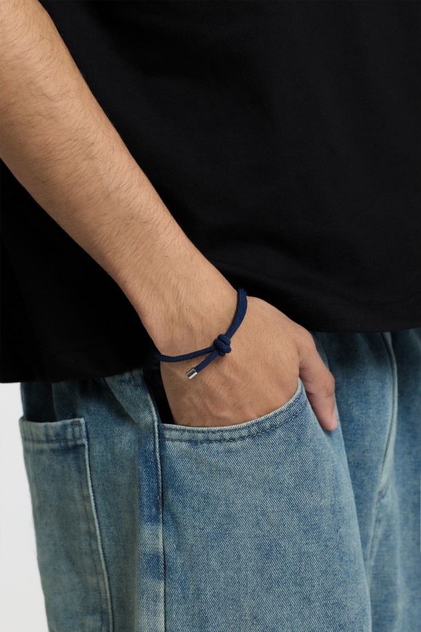 씨알에스디엘 크림소다 심플 스트링 팔찌는 미니멀하고 캐주얼한 스타일을 추구하는 분들을 위한 팔찌입니다. 네이비 색상의 마이크로 파이버 소재 스트링에 스테인리스 스틸 소재의 메달형 끝단과 브랜드 태그가 더해져 은은한 광택을 선사합니다. 부드러운 촉감과 더블 노트 구조로 편안한 착용감을 제공하며, 매듭 구조를 통해 사이즈 조절이 가능합니다. 단독 또는 레이어드하여 다양한 스타일을 연출할 수 있는 데일리 아이템입니다.
