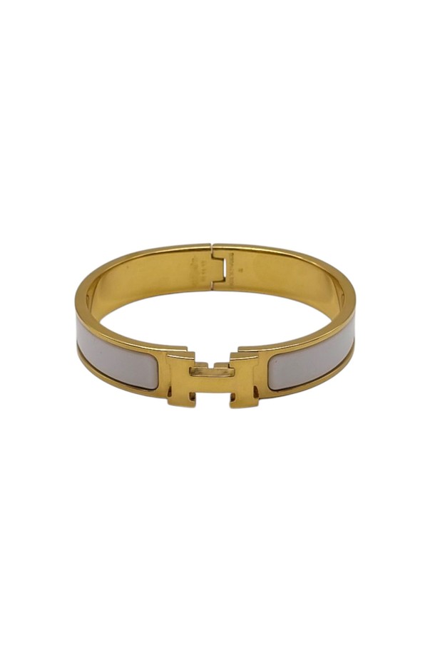 에르메스 클릭아슈 팔찌는 골드 컬러 메탈 소재에 화이트 에나멜 장식이 더해진 여성용 팔찌입니다. H 버클 디자인과 클릭 잠금 방식으로 미니멀하면서도 클래식한 스타일을 연출하며, 일상에서 착용하기 좋습니다. 섬세한 디자인이 돋보이는 에르메스 팔찌로 당신의 스타일을 완성해보세요.
