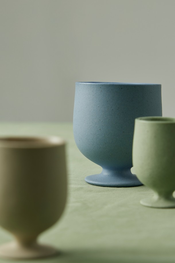 세라믹 소재의 고블렛 250ml (3colors)입니다. BLUE, BEIGE, GREEN 3가지 색상으로 출시되어 취향에 맞게 선택할 수 있습니다. 안정적인 실루엣과 자연스러운 곡선, 무광 표면 디자인이 특징이며, 내부 투명 유약 처리와 외부 발수 처리로 실용성을 높였습니다. 전자레인지 및 식기세척기 사용이 가능하며, 부드럽고 단단한 점토 질감과 매끄러운 연마 마감, 자연스러운 표면 질감을 느껴보세요. 직화 사용은 불가합니다.
