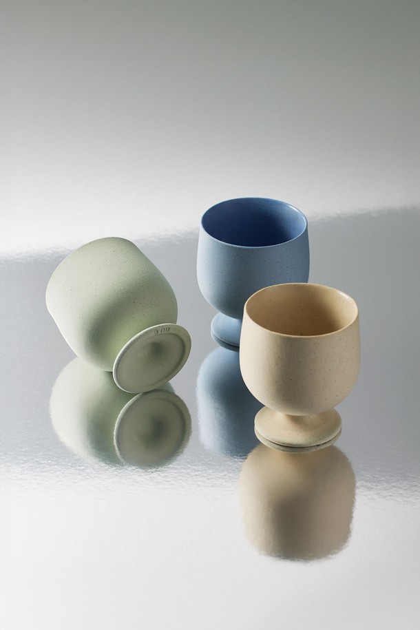 고블렛 150ml. 그린은 미니멀한 곡선형 디자인의 도자기 고블렛입니다. 150ml 용량으로 음료, 에스프레소, 주류 등 다양한 용도로 활용 가능합니다. 외부 발수 처리와 내부 유약 처리로 사용 편의성을 높였으며, 재활용 소재 10%를 함유하여 친환경적입니다. 전자레인지 및 식기세척기 사용이 가능하며, 외부에서는 자연스러운 점토 질감을, 내부에서는 매끄러운 유약 질감을 느낄 수 있습니다. 유해물질 안전 검사를 완료했으며, 직화 사용은 불가합니다.
