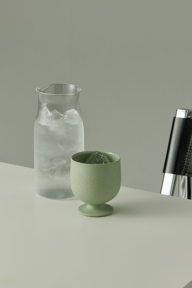 고블렛 150ml. 그린은 미니멀한 곡선형 디자인의 도자기 고블렛입니다. 150ml 용량으로 음료, 에스프레소, 주류 등 다양한 용도로 활용 가능합니다. 외부 발수 처리와 내부 유약 처리로 사용 편의성을 높였으며, 재활용 소재 10%를 함유하여 친환경적입니다. 전자레인지 및 식기세척기 사용이 가능하며, 외부에서는 자연스러운 점토 질감을, 내부에서는 매끄러운 유약 질감을 느낄 수 있습니다. 유해물질 안전 검사를 완료했으며, 직화 사용은 불가합니다.
