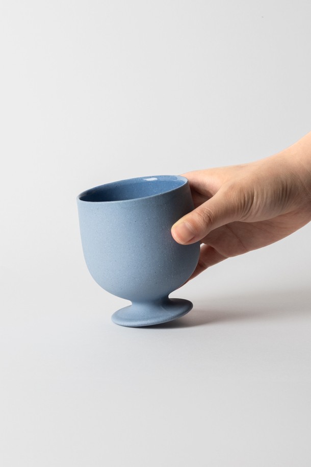 "고블렛" 150ml (3colors)는 블루, 베이지, 그린 3가지 색상으로 제공되는 세라믹 소재의 고블렛입니다. 150ml 용량으로 티타임, 카페 음료, 와인, 아이스크림, 요거트, 디저트 등을 담기에 적합합니다. 전자레인지 및 식기세척기 사용이 가능하며, 방수 처리와 립스틱 자국 방지 기능으로 실용성을 높였습니다. 외부 무광택 마감과 내부 유약 처리, 부드러운 곡선과 견고한 그립감, 자연스러운 표면 질감이 특징입니다. 납, 비소, 카드뮴 무첨가로 안심하고 사용할 수 있으며, 직화 사용은 불가합니다.
