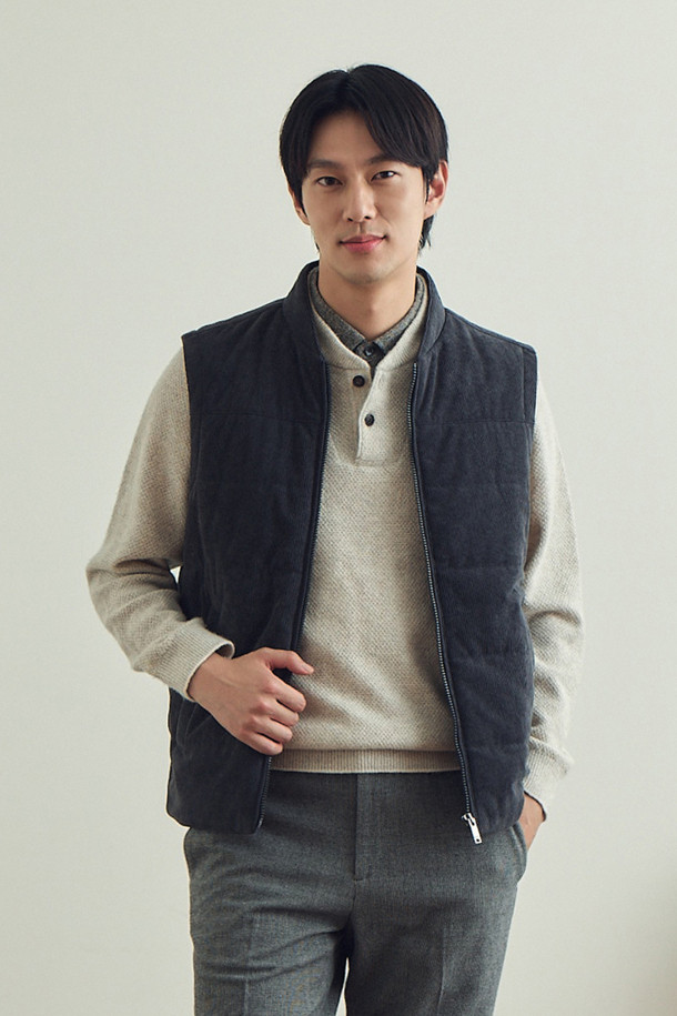 [코지] 코듀로이 베스트는 초겨울, 출근룩에 어울리는 베이직하고 캐주얼한 스타일의 베스트입니다. 엉덩이 위 기장의 레귤러핏으로, 반달 모양의 네크라인과 전면 노출 지퍼가 특징입니다. 블랙 컬러의 폴리에스터 코듀로이 소재에 퀼팅 패턴으로 포인트를 주었으며, 약간 두꺼운 두께감과 3M 신슐레이트 안감으로 보온성을 높였습니다. 사이드 스냅 포켓과 뒷넥 라벨판 체크 배색 디테일, 약간의 신축성이 있어 편안하게 착용 가능합니다.
