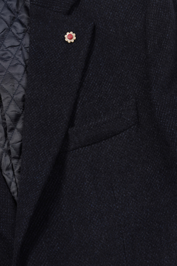 네이비 컬러의 울캐시미어 브러쉬드 퀼팅 자켓입니다. 울과 캐시미어 혼방 소재로 제작되어 부드럽고 고급스러운 착용감을 선사합니다. 테일러드 칼라와 투버튼 여밈 디자인, 플랩 포켓, 사이드벤트, 부토니에 장식, 속주머니 디테일이 특징입니다. 안감은 퀼팅 처리되어 보온성을 높였으며, 레귤러핏으로 제작되어 포멀한 오피스룩, 비즈니스 캐주얼, 겨울 데일리룩에 모두 잘 어울립니다. 클래식하고 미니멀한 스타일을 연출하기에 좋습니다.
