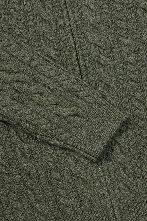 **울100 케이블 집업 가디건**은 초겨울부터 겨울까지 따뜻하게 입을 수 있는 남성용 상의입니다. 부드러운 촉감의 울 100% 소재로 제작되었으며, 레귤러 핏과 두꺼운 두께로 포근함을 더합니다. 그린과 투톤 컬러로 세련된 느낌을 주며, 케이블 패턴과 긴 소매 디자인이 특징입니다. 밑단 및 소매단 립 처리와 좌측 포켓 스웨이드 와펜 디테일이 돋보이며, 지퍼 여밈 방식으로 편안하게 착용 가능합니다. 일상, 모임, 데이트 등 다양한 TPO (Time, Place, Occasion) 에 맞춰 클래식, 미니멀, 캐주얼 스타일을 연출할 수 있는 활용도 높은 아이템입니다.
