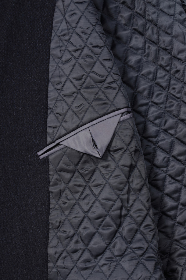 네이비 컬러의 울캐시미어 브러쉬드 퀼팅 자켓입니다. 울과 캐시미어 혼방 소재로 제작되어 부드럽고 고급스러운 착용감을 선사합니다. 테일러드 칼라와 투버튼 여밈 디자인, 플랩 포켓, 사이드벤트, 부토니에 장식, 속주머니 디테일이 특징입니다. 안감은 퀼팅 처리되어 보온성을 높였으며, 레귤러핏으로 제작되어 포멀한 오피스룩, 비즈니스 캐주얼, 겨울 데일리룩에 모두 잘 어울립니다. 클래식하고 미니멀한 스타일을 연출하기에 좋습니다.
