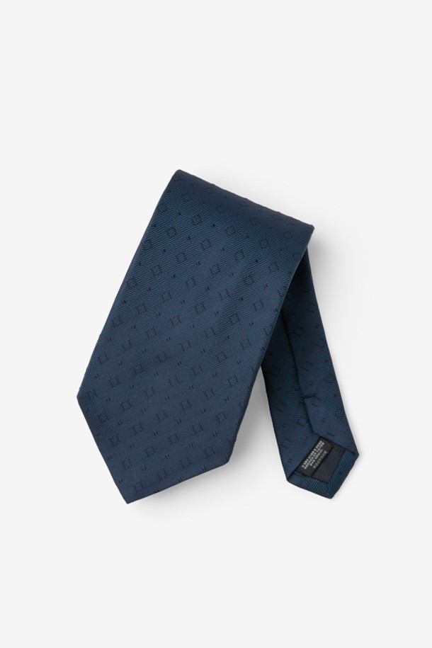 네이비 컬러의 변형 스퀘어 디자인이 돋보이는 남성용 타이입니다. 부드러운 실크 소재로 제작되어 고급스러운 촉감을 선사하며, 일상에서 편안하게 착용하기 좋습니다. 안쪽에 루프 장식이 있어 넥타이를 깔끔하게 정리할 수 있으며, 로고 자수 디테일이 은은한 포인트를 더합니다. 클래식하고 미니멀한 스타일로 오피스룩, 비즈니스 캐주얼, 모임룩 등 다양한 TPO에 활용 가능합니다.
