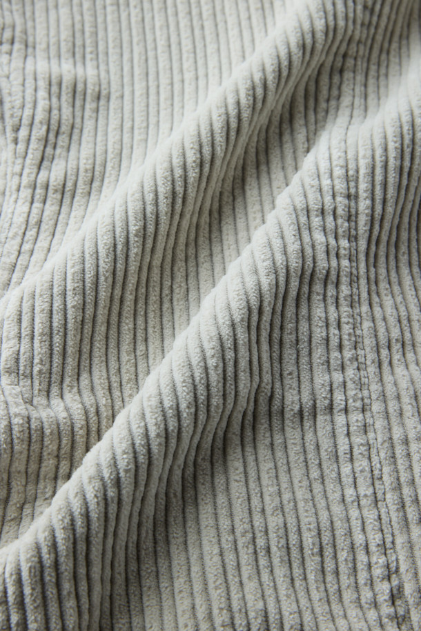 **SANTANIELLO(산타니엘로) 볼드 코듀로이 재킷**은 남성용 자켓으로, 캐주얼, 클래식, 미니멀 스타일을 모두 아우르는 매력적인 아이템입니다. 봄, 가을에 착용하기 적합하며, 출근룩으로도 활용할 수 있습니다. 그레이 컬러의 레귤러핏 자켓으로, 볼드한 코듀로이 원단과 싱글 버튼 디테일이 특징입니다. 두께감 있는 코듀로이 소재는 뻣뻣한 촉감을 선사하며, 긴 소매 기장으로 제작되었습니다. 
