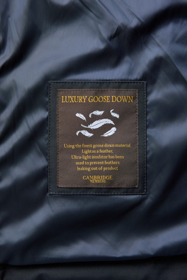 듀크 구스다운 파카는 겨울철 캐주얼 및 일상룩에 적합한 남성용 아우터입니다. 네이비 색상의 무지 디자인으로, 후드 탈착이 가능하며 경량 구스다운 충전재를 사용하여 보온성을 높였습니다. 지퍼와 버튼으로 여밀 수 있으며, 중기장 기장의 레귤러핏으로 제작되어 편안한 착용감을 제공합니다. 출근룩과 여행룩 모두 소화 가능한 미니멀하고 베이직한 스타일의 파카입니다. 
