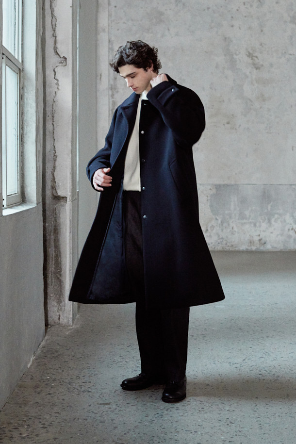 [MOVERE X ROLIAT] 발마칸 코트는 울과 캐시미어 혼방 소재로 제작되어 부드러운 촉감과 뛰어난 보온성을 제공합니다. 래글런 소매와 A라인 실루엣이 특징이며, 세미 루즈핏으로 편안하면서도 클래식한 스타일을 연출합니다. 무지 디자인의 블랙 컬러로, 출근룩, 오피스룩, 모임룩 등 다양한 TPO에 활용할 수 있습니다. 히든 포켓 디테일과 스냅 버튼 여밈 방식으로 미니멀하고 시크한 무드를 더했습니다. 가슴둘레 123cm의 넉넉한 기장감으로 겨울, 가을 시즌에 활용하기 좋습니다.
