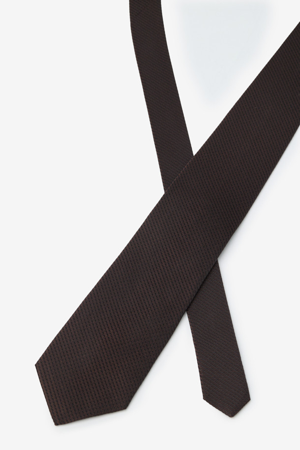 **실크 텍스쳐 솔리드 타이**는 남성용 포멀 넥타이입니다. 부드러운 촉감의 블랙 솔리드 컬러 실크 소재로 제작되어 클래식하고 시크한 스타일을 연출합니다. 오피스룩, 비즈니스 캐주얼, 모임룩 등 다양한 TPO에 활용 가능하며, 얇은 두께감으로 답답함 없이 착용할 수 있습니다. 넥타이 끝단에는 로고 자수가 디자인되어 섬세한 포인트를 더합니다.
