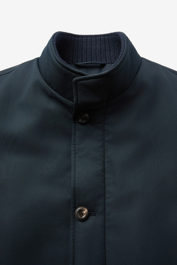 네이비 컬러의 스탠드 니트카라 구스다운 트렌치 코트입니다. 캐주얼, 클래식, 미니멀한 스타일을 모두 아우르는 디자인으로, 일상과 출근룩에 모두 활용 가능합니다. 두꺼운 두께감으로 겨울철 보온성을 높였으며, 유로피안 구스다운 충전재와 메리노 무스탕 배색으로 고급스러움을 더했습니다. 스탠드 카라와 니트 카라 디테일이 돋보이며, 레귤러핏으로 편안하게 착용할 수 있습니다. 경량 기능으로 활동성 또한 놓치지 않았습니다.
