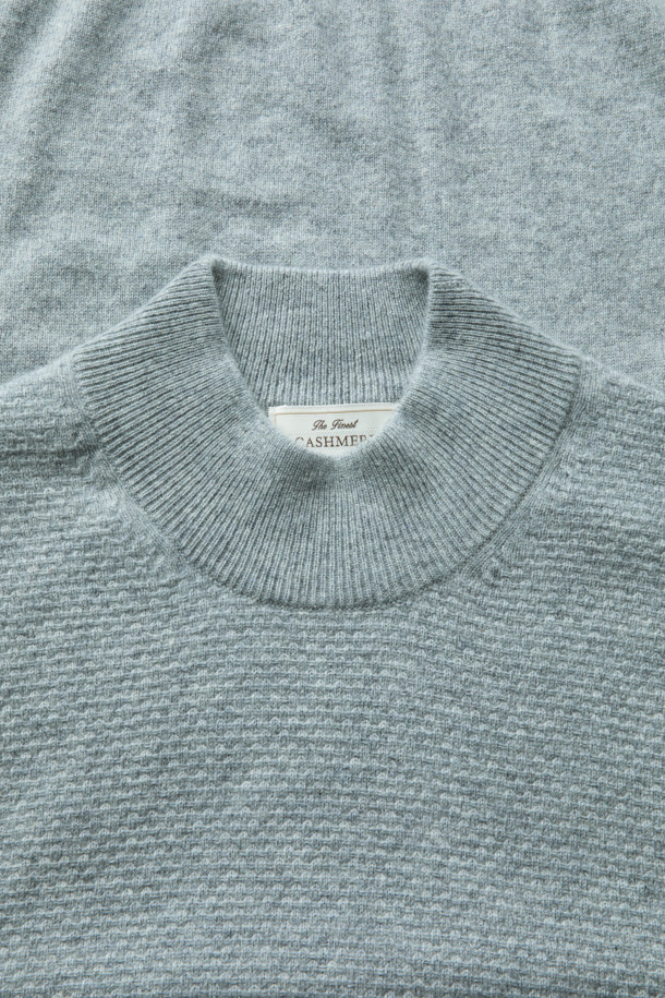 캐시미어 100% 소재로 제작된 하프 터틀넥 니트입니다. 은은하고 고급스러운 라이트 그레이 컬러로, 우아하고 베이직한 스타일을 연출합니다. 쌀쌀한 가을, 겨울 시즌에 포근함을 선사하며, 출근룩, 오피스룩, 모임룩 등 다양한 TPO에 활용 가능합니다. 볼륨감 있는 조직감과 부드러운 촉감으로 편안하게 착용할 수 있으며, 클래식하면서도 미니멀한 디자인으로 폭넓은 스타일을 소화합니다.
